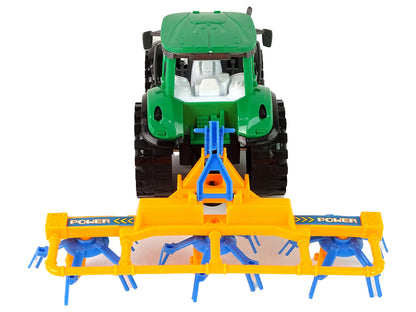 Grüner Traktor mit orangefarbener und blauer Harke Reibungsantrieb