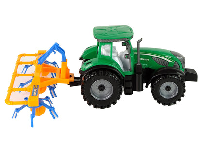 Grüner Traktor mit orangefarbener und blauer Harke Reibungsantrieb