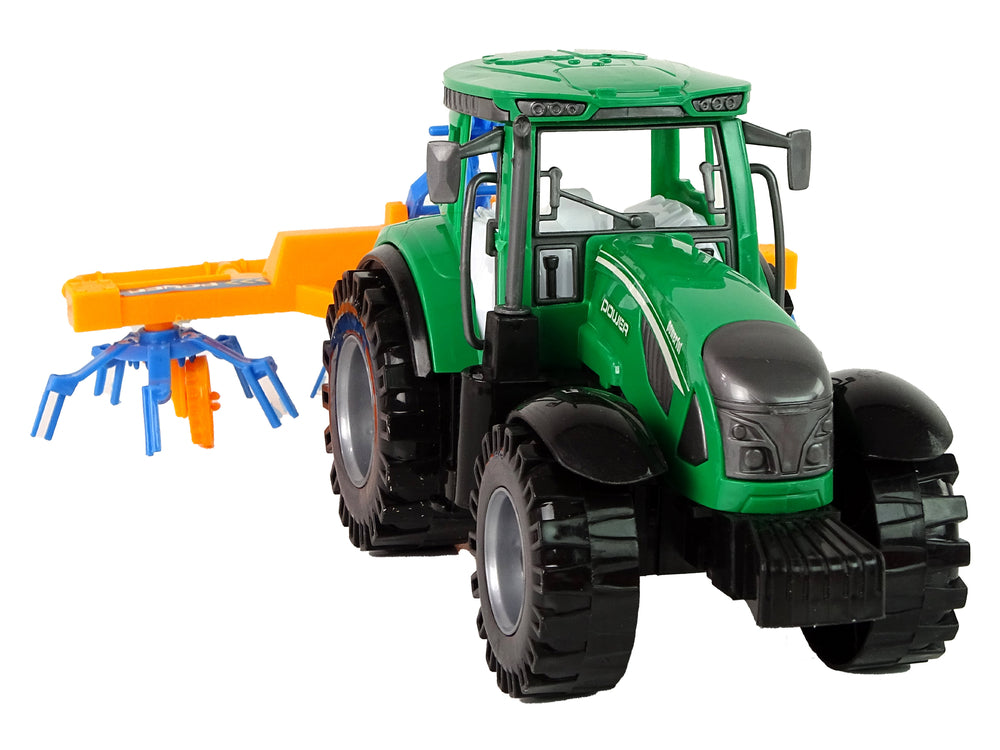 Grüner Traktor mit orangefarbener und blauer Harke Reibungsantrieb